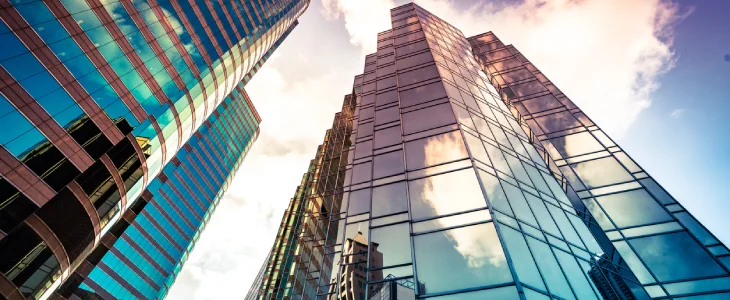 Looking up a reflections on glass covered corporate building